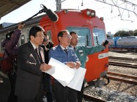 川勝知事(左)は岳南鉄道吉原駅のホームで貨物輸送の現状や敷設状況を確認した